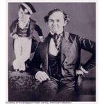 Two circus performers, a man with an infant sized man standing near him, courtesy of the Bridgeport Public Library Historical Collections